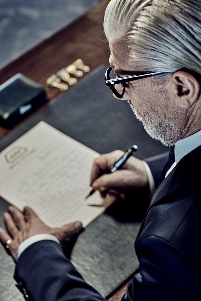 gentleman writing letter, stylish office setting, classic stationary
