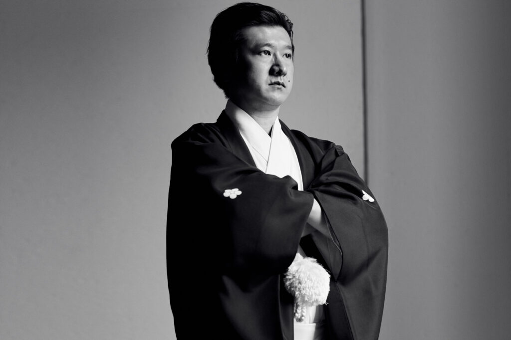 Masatsugu Okutani in black and white portrait, arms crossed in traditional kimono, photographed by Bert Spangemacher