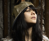 Portrait of musician Bat for Lashes (Natasha Khan) in a gold cap, photographed in New York City by Bert Spangemacher